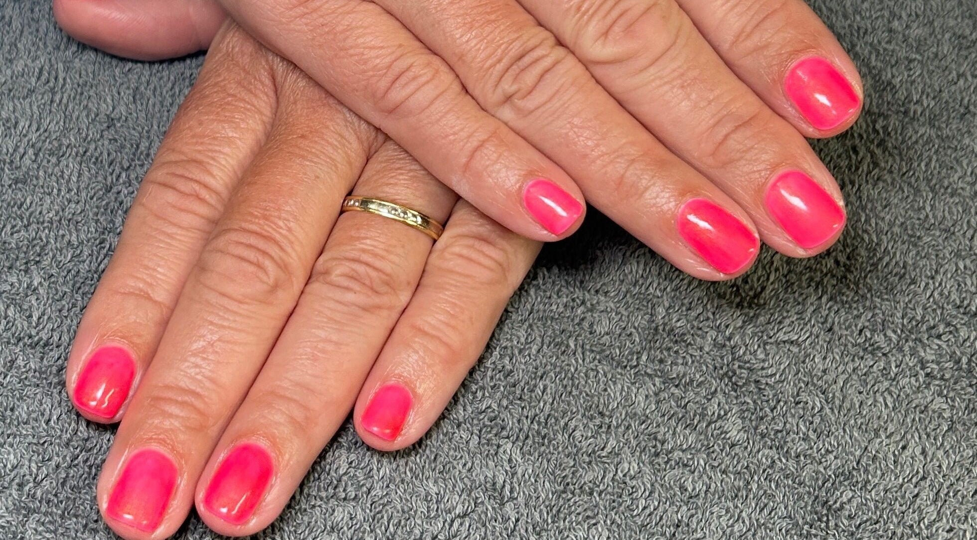 Vibrant pink nails at Isle of Beauty, Peterborough, England, GB showcasing elegant manicure finish.