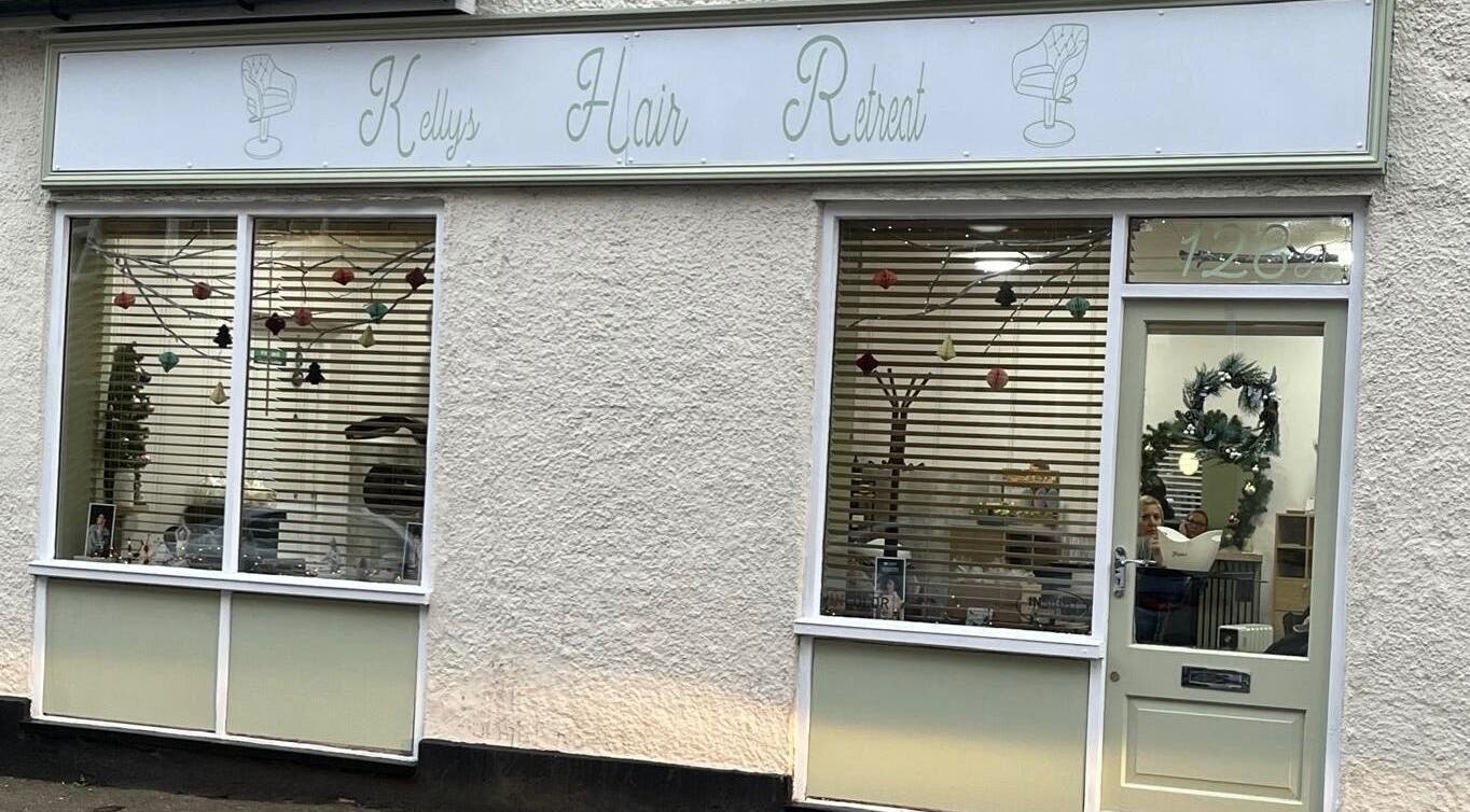 Exterior of Hair by Kelly salon in Hoddesdon, England with stylish window decor and inviting entrance.