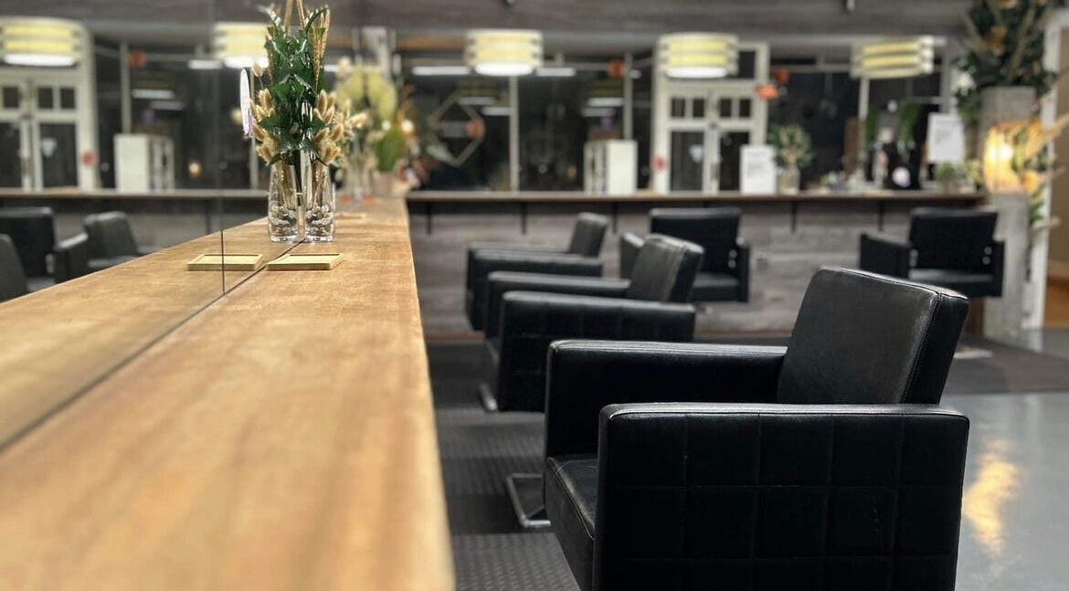 Elegant salon interior at Hair Couture Tranent Ltd, Tranent, Scotland, GB, featuring sleek black chairs and modern decor.