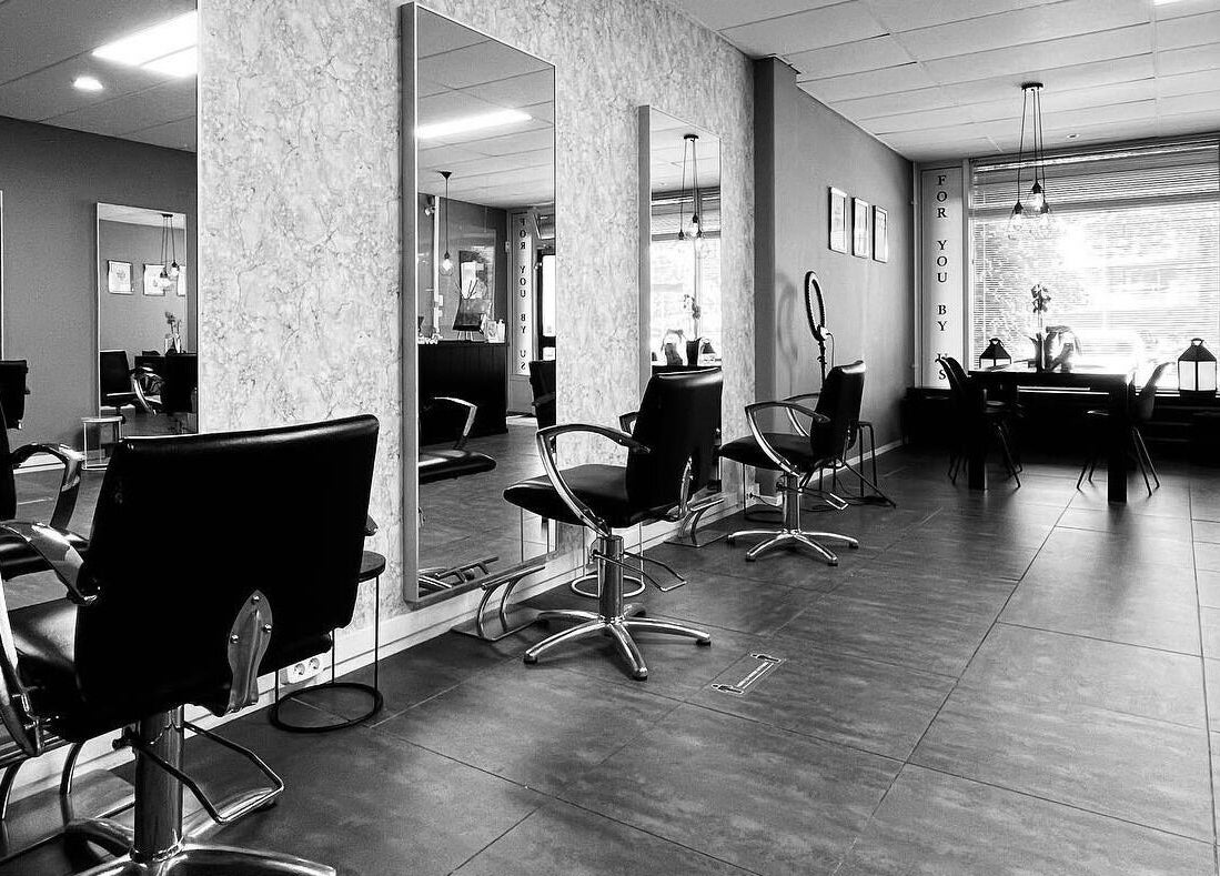 Binnenkant van Yous Krullenspecialist, Almere, Flevoland, NL, met moderne kappersstoelen en spiegels.