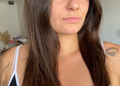 Close-up of a woman with sleek, long brown hair at Luxe Hair Lab, Kyneton, Victoria, AU.