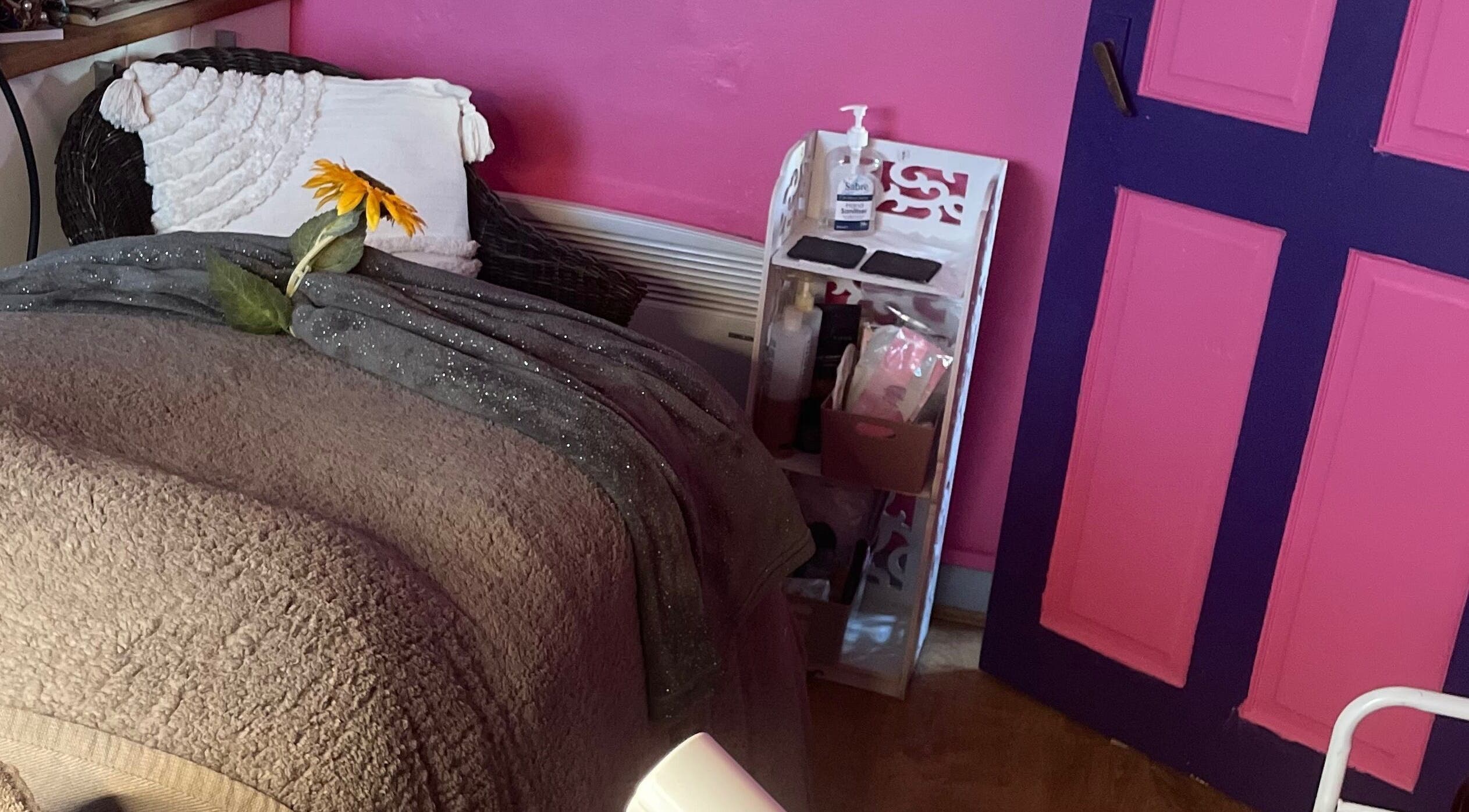 Comfortable treatment room at A Little Unorthodox, Allesley Coventry, England, GB with pink walls and sunflowers.