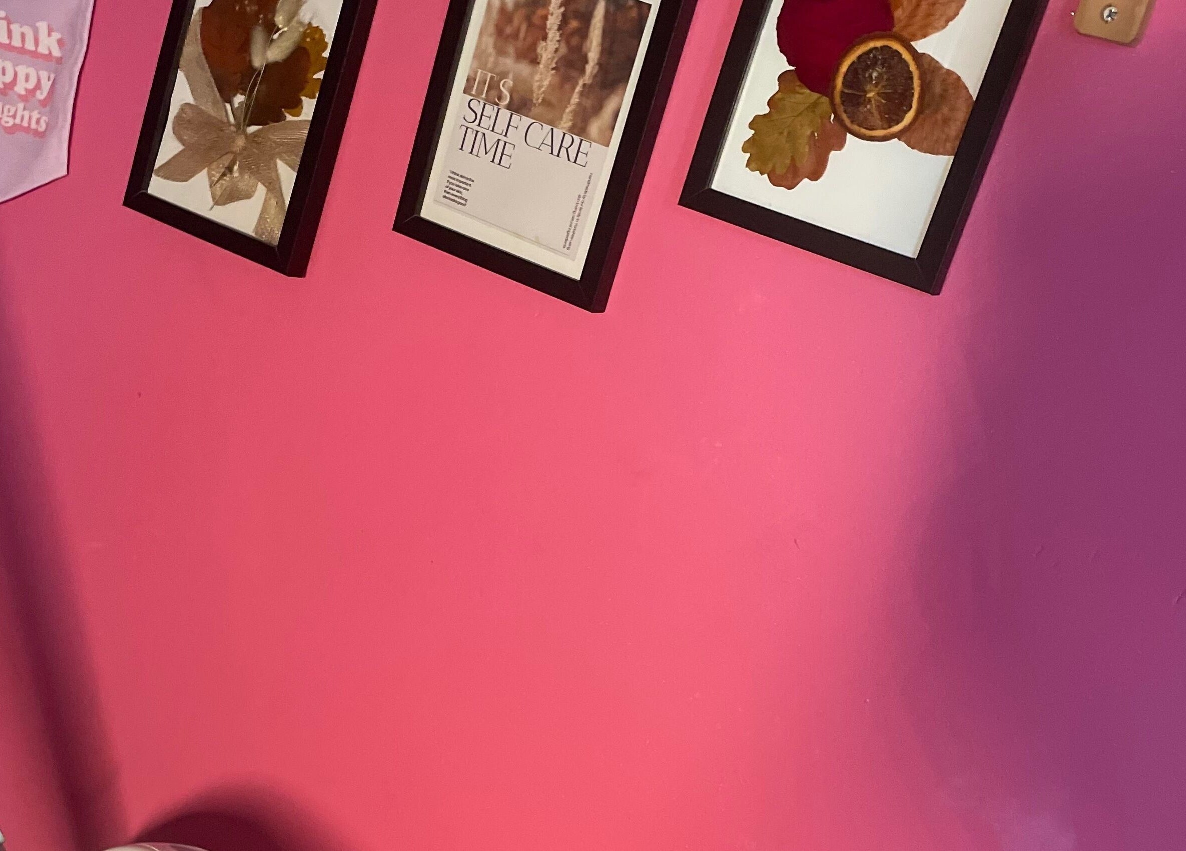 Colorful framed art on a pink wall at A Little Unorthodox in Allesley Coventry, England, GB.