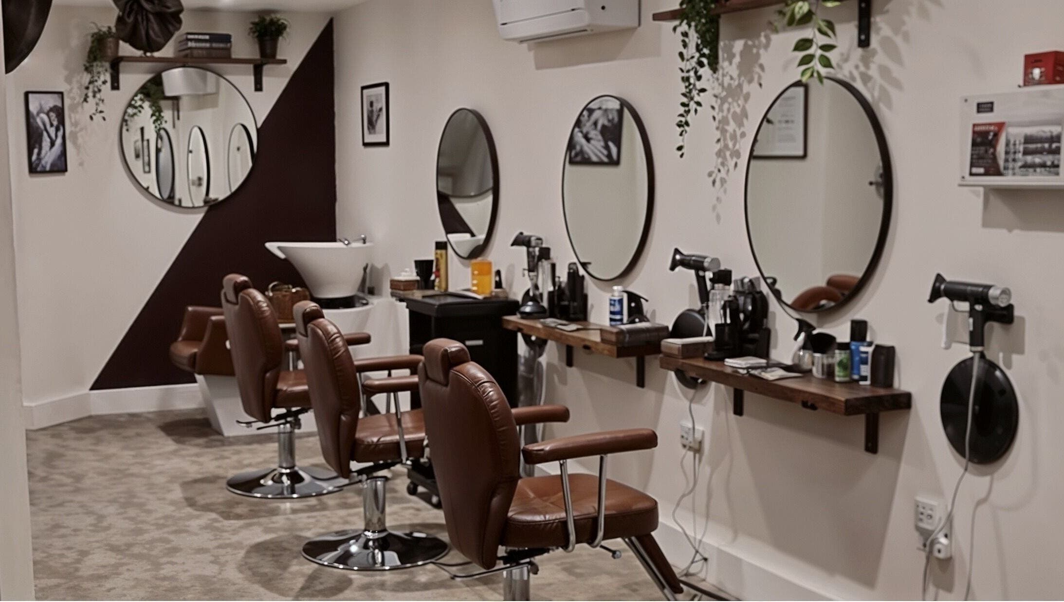 Interior view of Copper Row Barbers in London, England, GB showcasing modern barber chairs and mirrors.