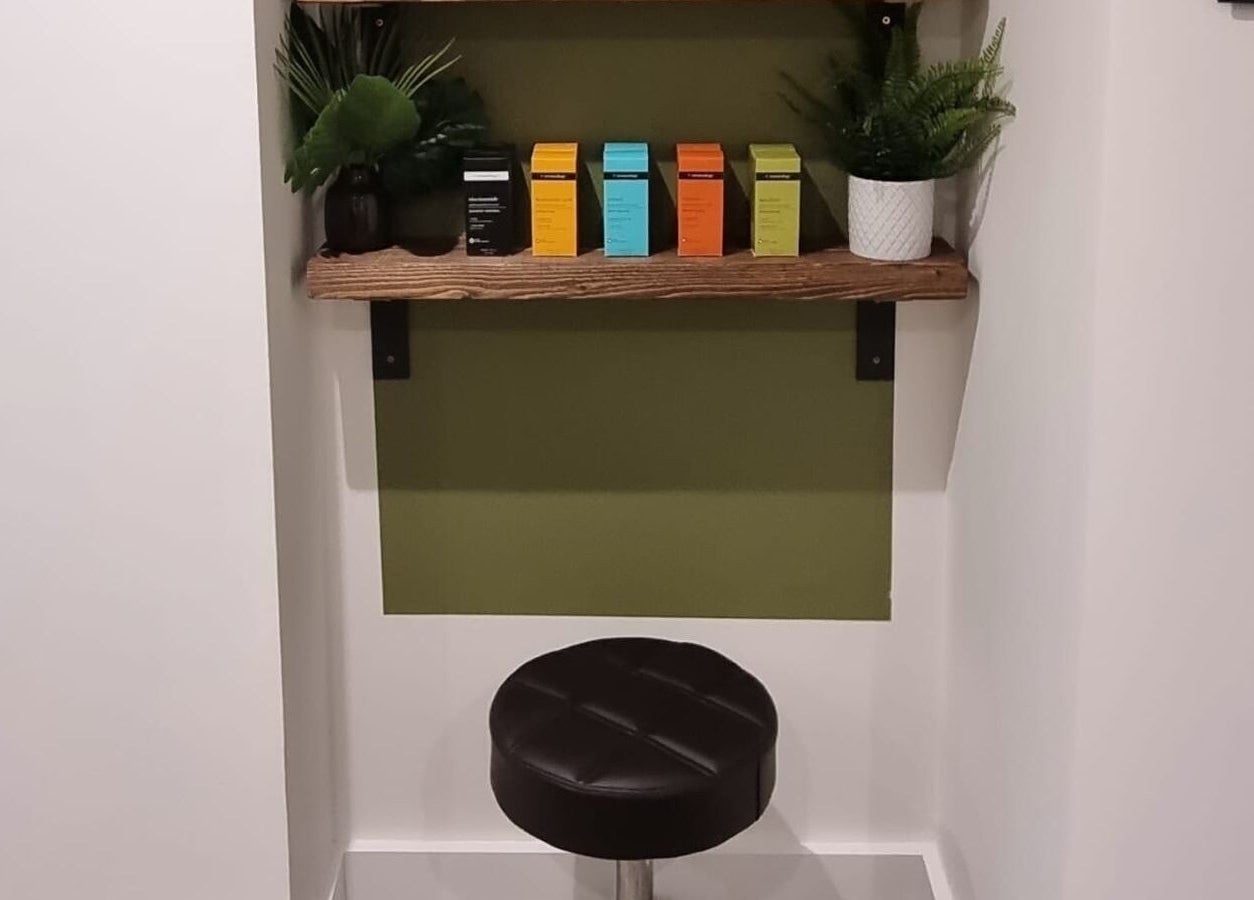 Stylish seating at Copper Row Barbers, London, England, GB showcasing a modern shelf with plants.