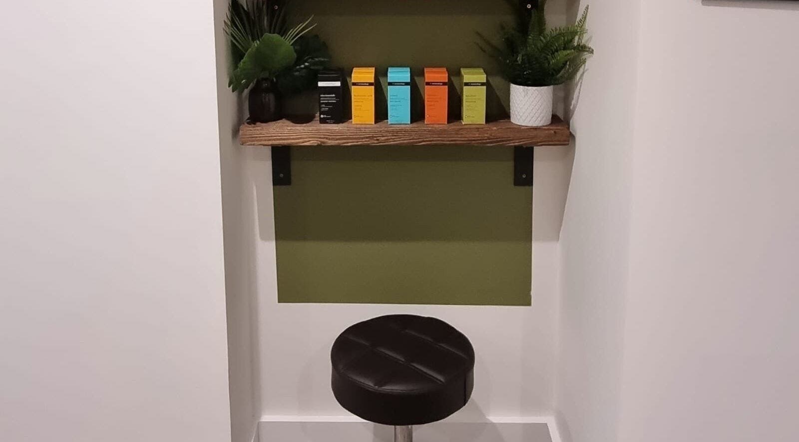 Stylish seating at Copper Row Barbers, London, England, GB showcasing a modern shelf with plants.