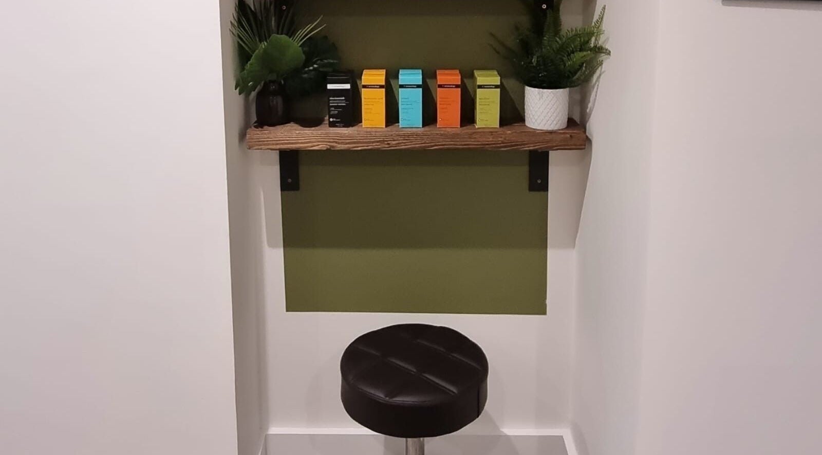 Stylish seating at Copper Row Barbers, London, England, GB showcasing a modern shelf with plants.