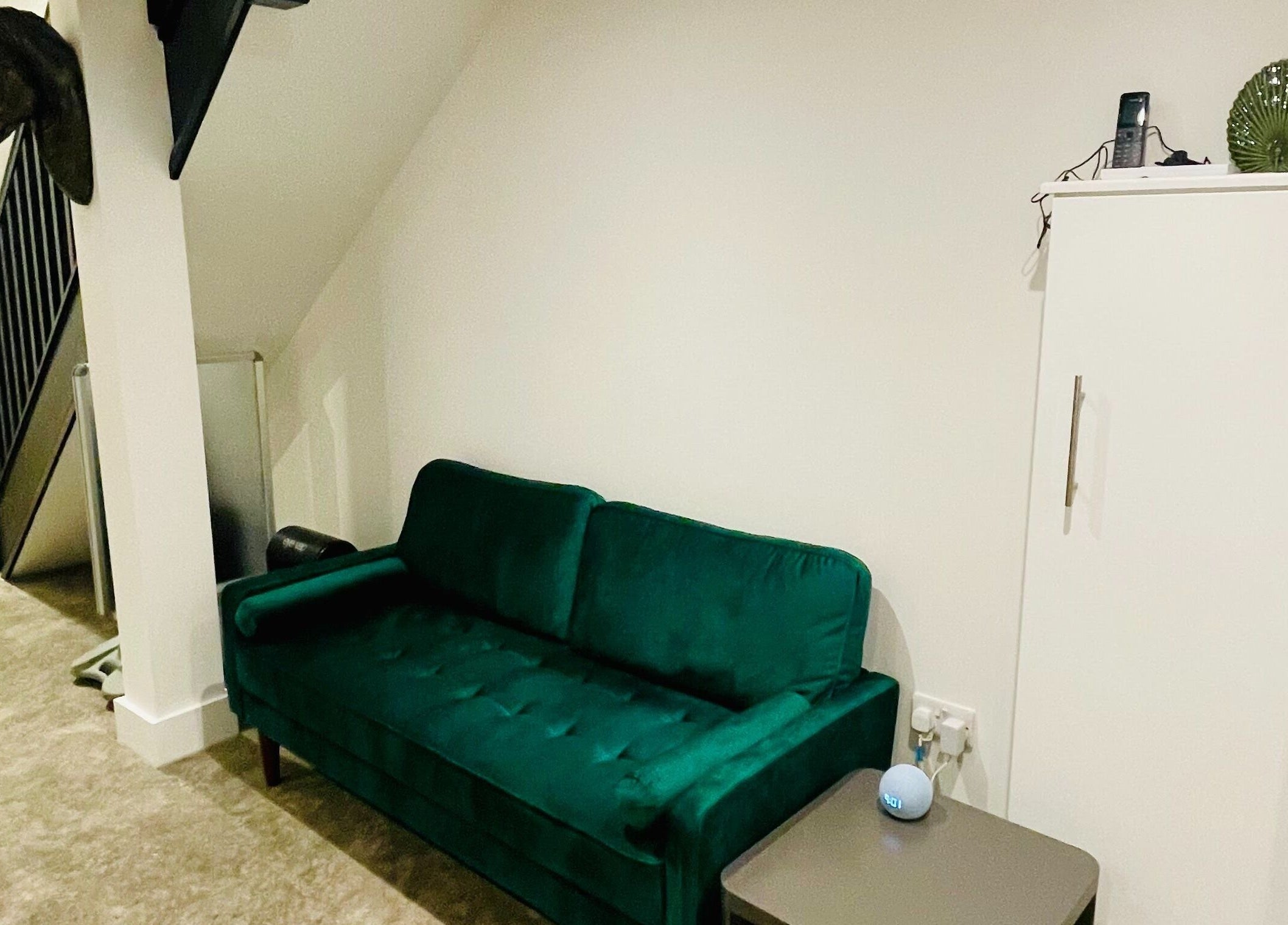 Stylish green sofa in Copper Row Barbers, London, England, GB, complementing modern decor.