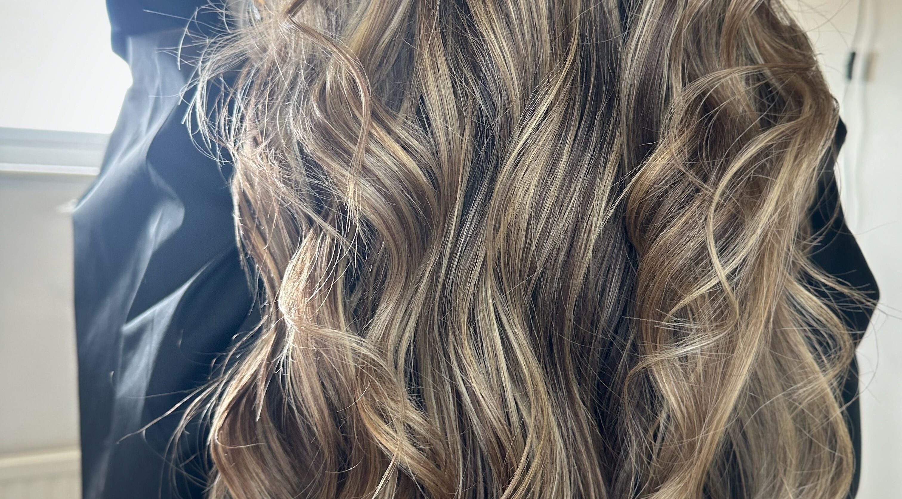 Elegant wavy hairstyle at The Glow Up Bar, Ruislip, England, GB.