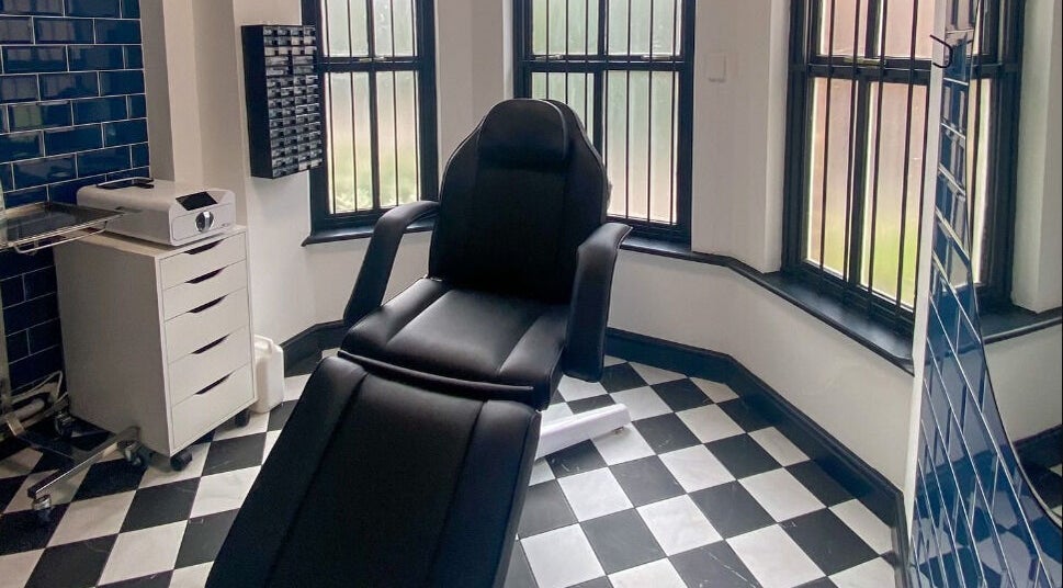 Professional piercing chair at Arcade Eight Piercing, Newport Pagnell, England, GB with stylish decor.