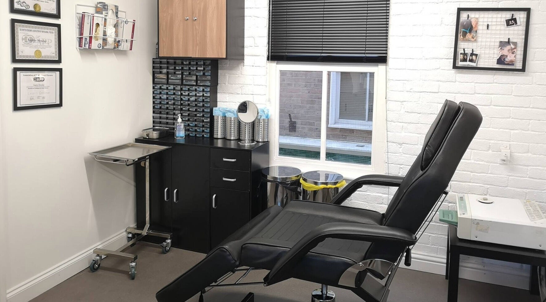 Modern piercing studio at Arcade Eight Piercing, Newport Pagnell, England, GB with a reclining chair and clean setup.