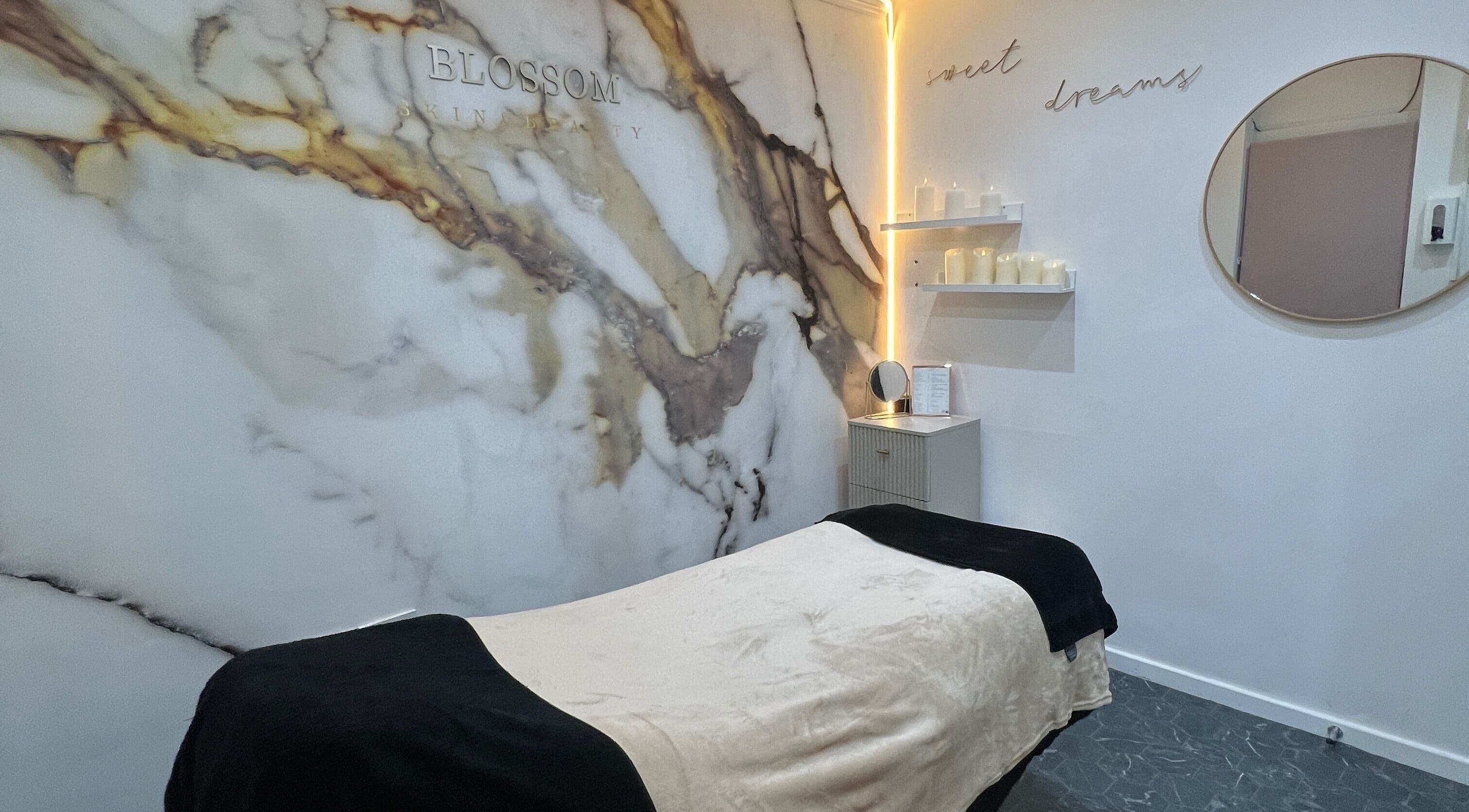 Relaxing massage room at Blossom Beauty, Radcliffe North, England, GB with elegant marble decor and ambient lighting.