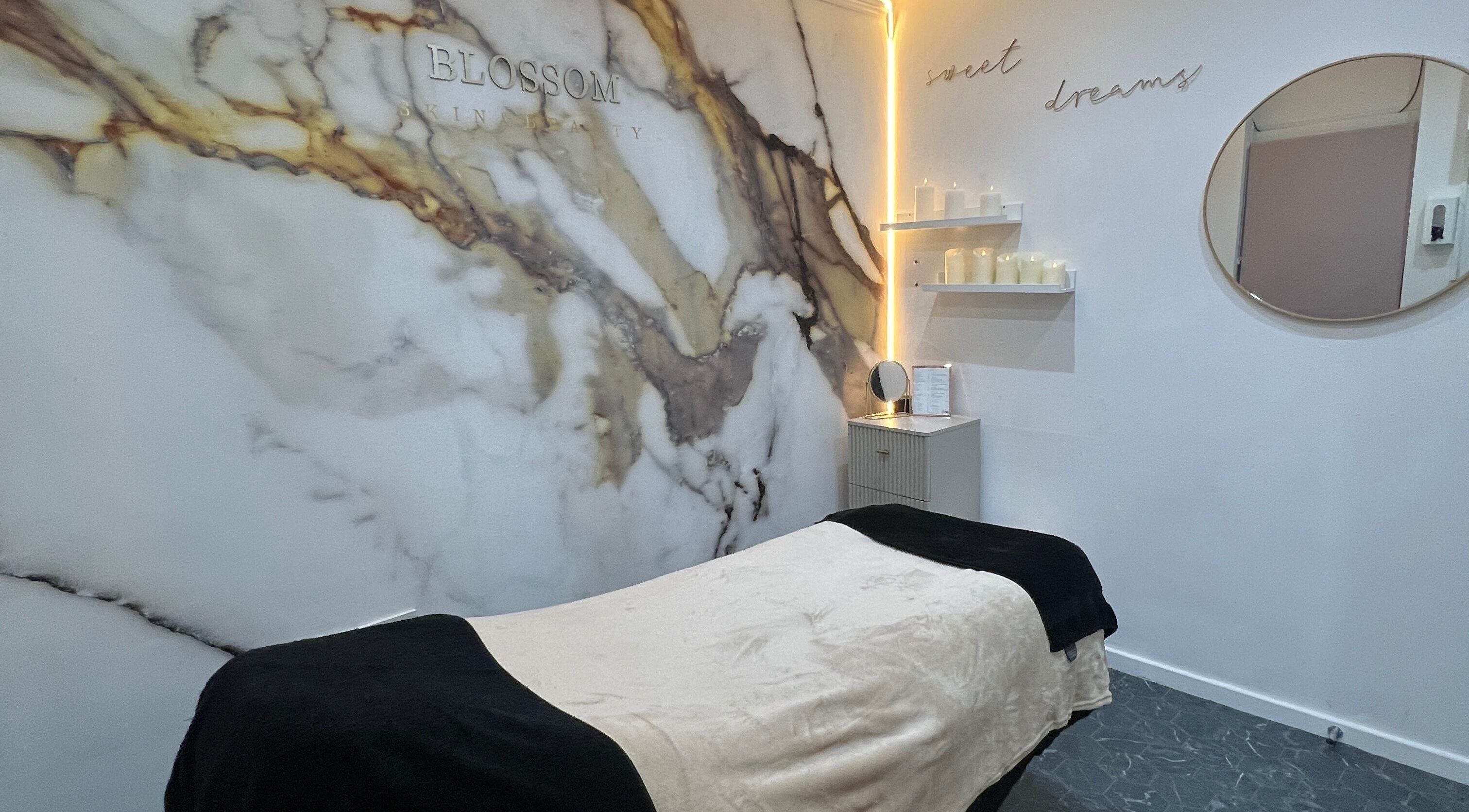 Relaxing massage room at Blossom Beauty, Radcliffe North, England, GB with elegant marble decor and ambient lighting.