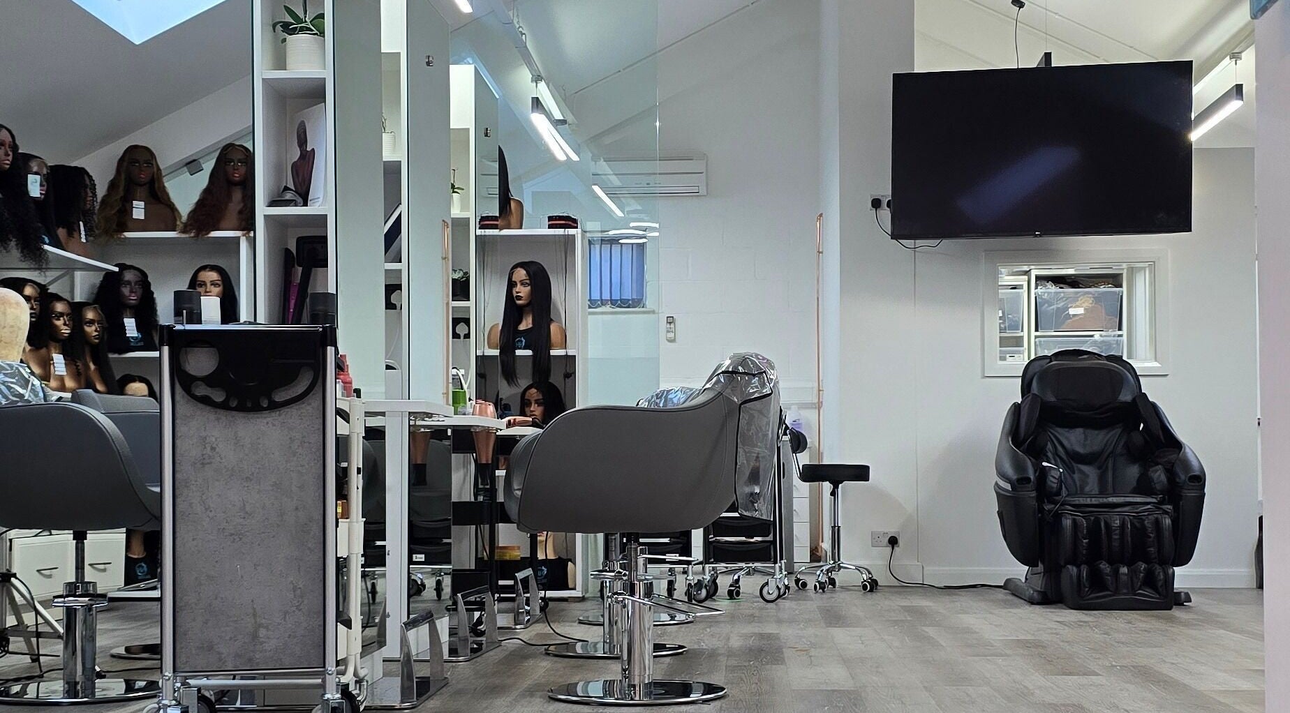 Modern salon interior at Happy Hair - UK, Abbots Langley, England, featuring styling chairs and mirrors.