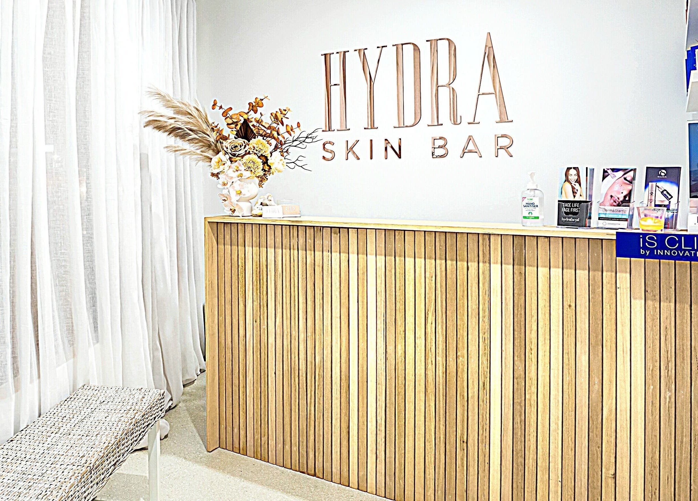 Elegant reception at Hydra Skin Bar in Melbourne, Victoria, AU featuring a modern wooden desk and skincare displays.