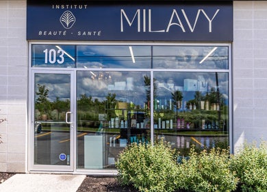 Entrée de l'Institut Beauté Santé Milavy à Mirabel, Québec, CA avec produits en vitrine et verdure.