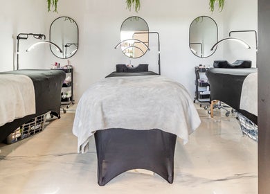 Salle de soins moderne à l'Institut Beauté Santé Milavy, Mirabel, Québec, CA, avec lits et miroirs élégants.