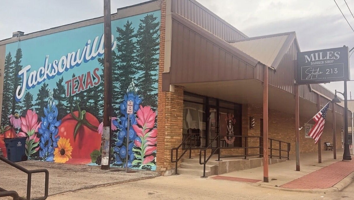 AMberly @Studio213 venue with vibrant Jacksonville, Texas mural and storefront.