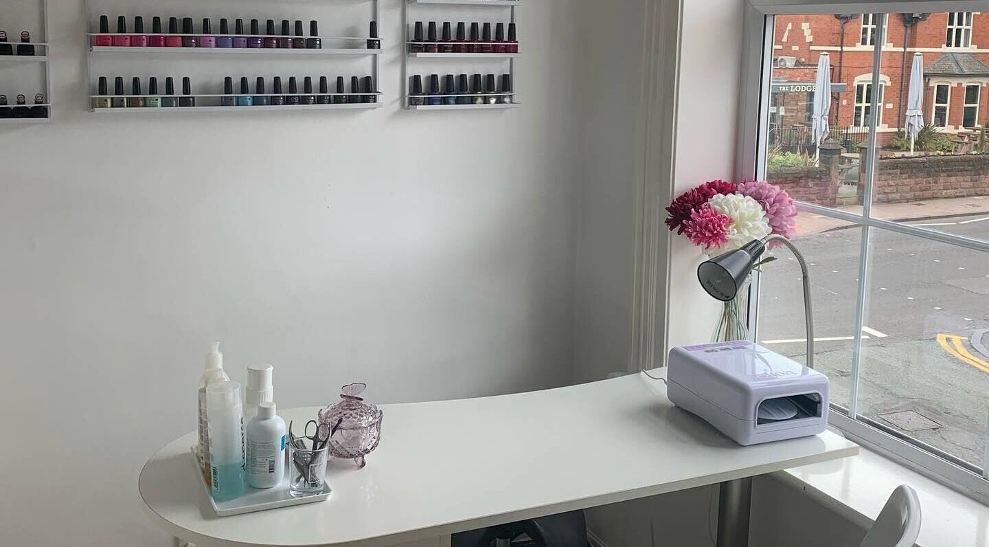 Cozy nail station at The Beauty Vault, Chester, England, GB, with a window view showcasing nail polish racks.