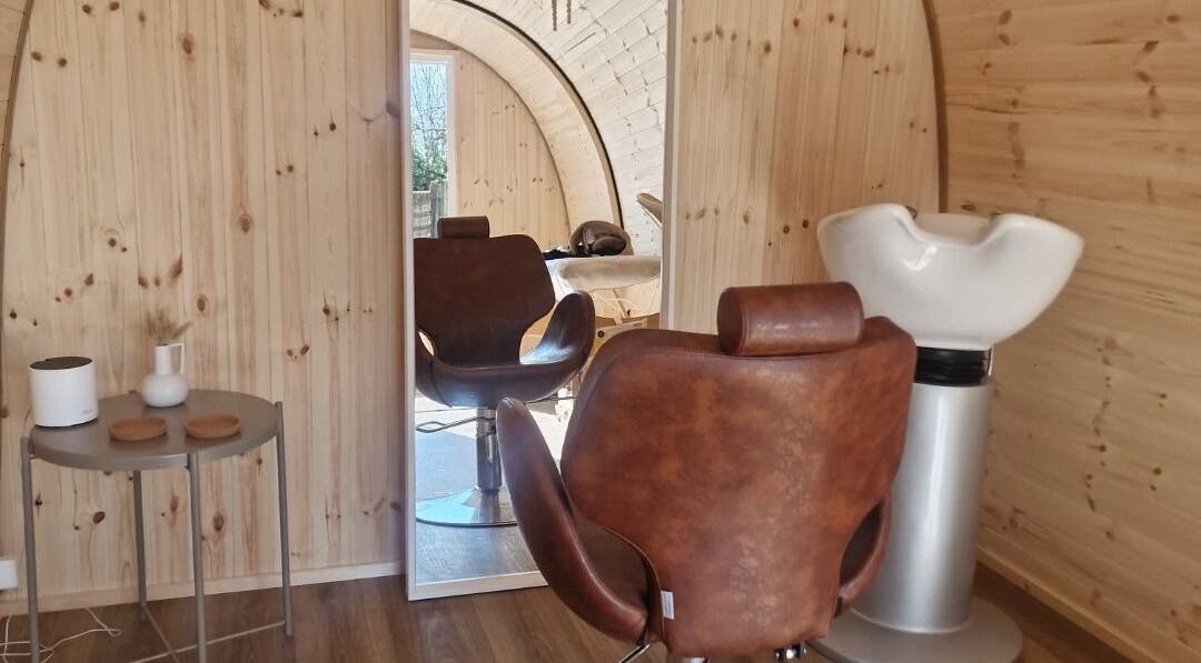 Karistyle salon interior with wooden decor and styling chair in Maidstone, England, GB.