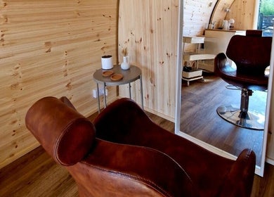 Cozy salon chair and mirror setup at Karistyle, Maidstone, England, GB, showcasing elegant decor and wooden interior.