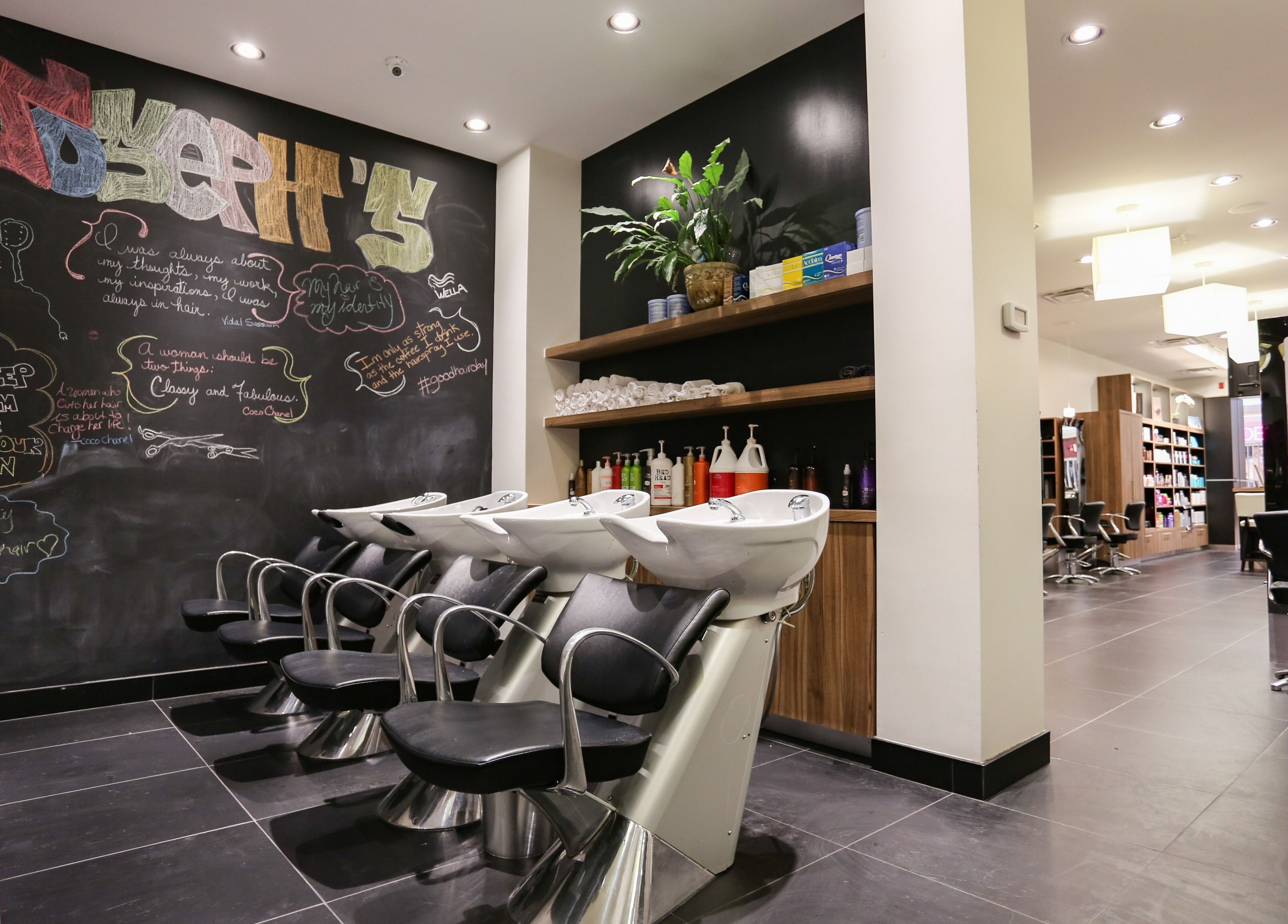Modern interior of Joseph's Coiffures salon in Ottawa, Ontario, CA with chic black chairs and wall art.