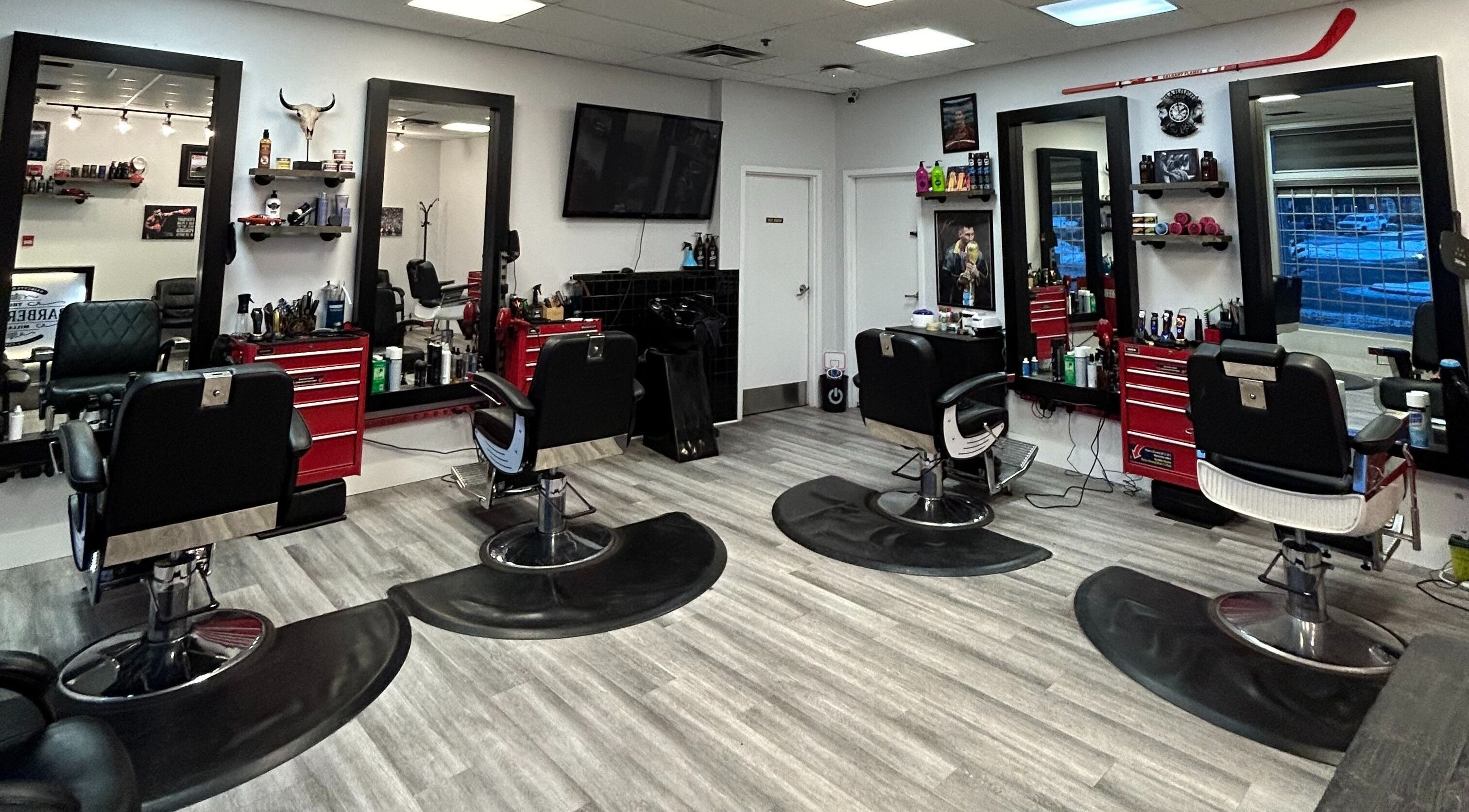 Interior of Brotherhood Barber Shop Millrise in Calgary, Alberta, CA showcasing modern chairs and styling stations.