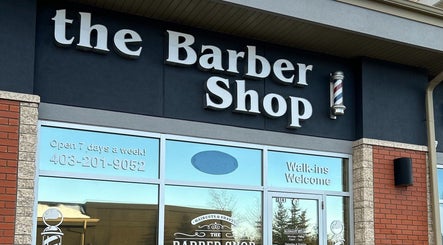Exterior view of Brotherhood Barber Shop Millrise in Calgary, Alberta, CA with open sign and barber pole.