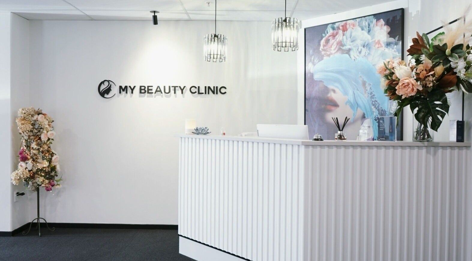 Reception area of My Beauty Clinic in Christchurch, Canterbury, NZ, showcasing modern decor and floral accents.