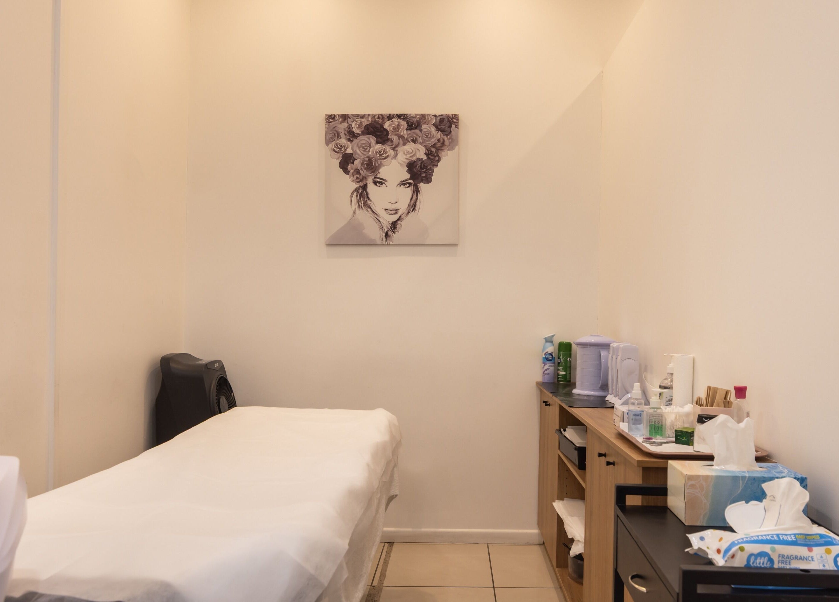 Cozy treatment room at Grace Threading- Myer Centre in Brisbane City, Queensland, AU with massage table and art.