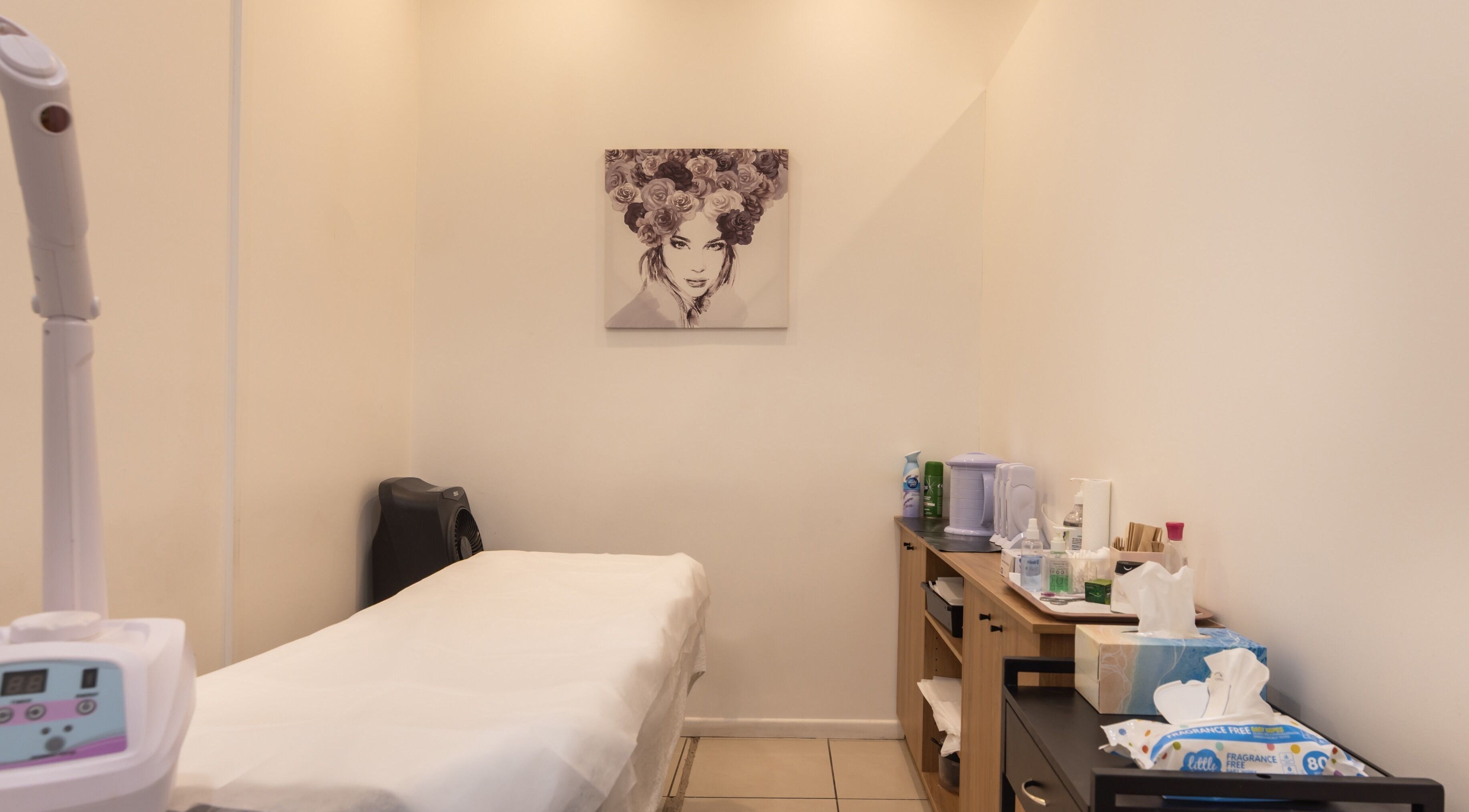 Cozy treatment room at Grace Threading- Myer Centre in Brisbane City, Queensland, AU with massage table and art.
