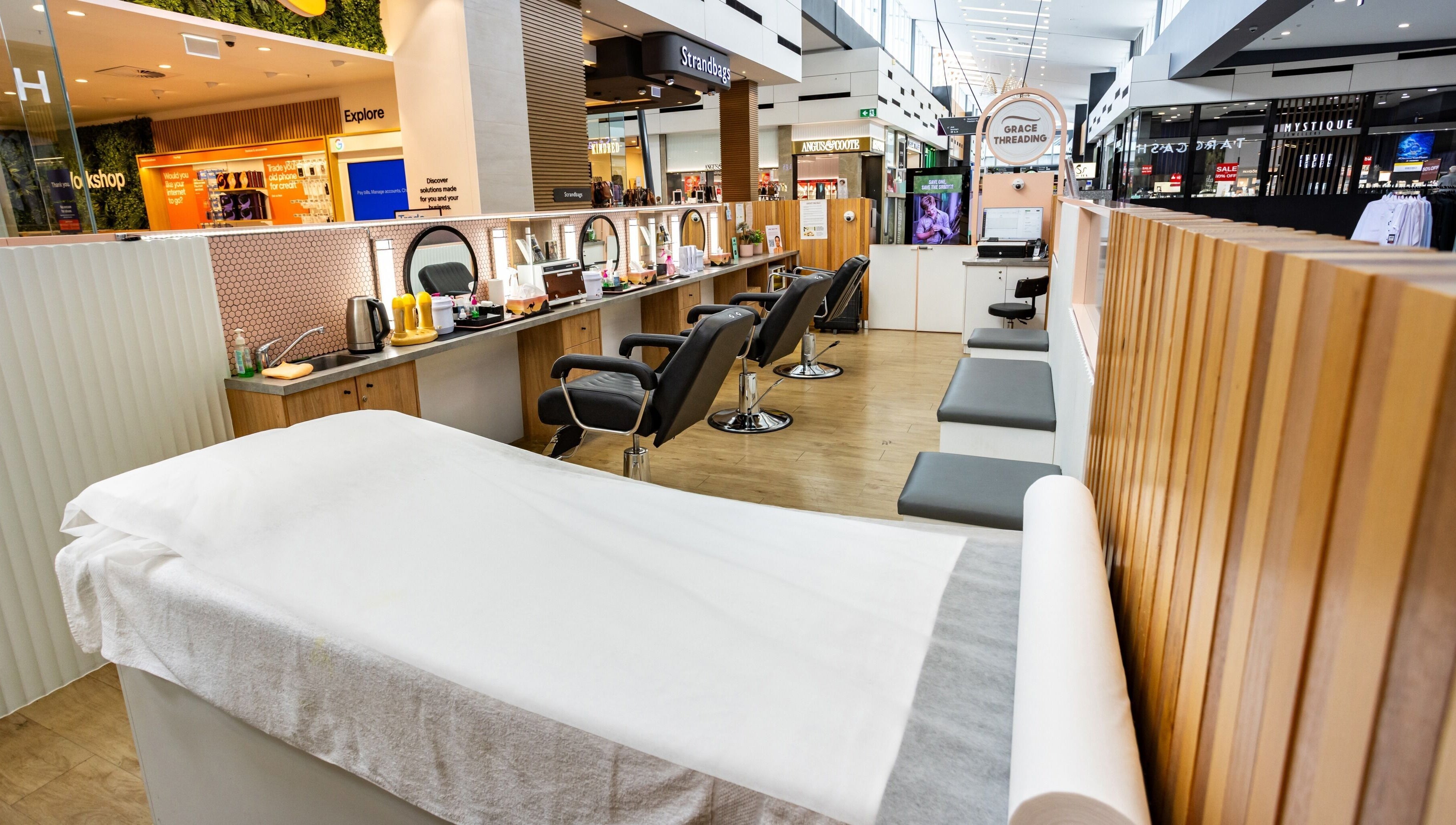 Grace Threading - Orion Springfield Central salon interior in Springfield Central, Queensland, AU with modern chairs and decor.