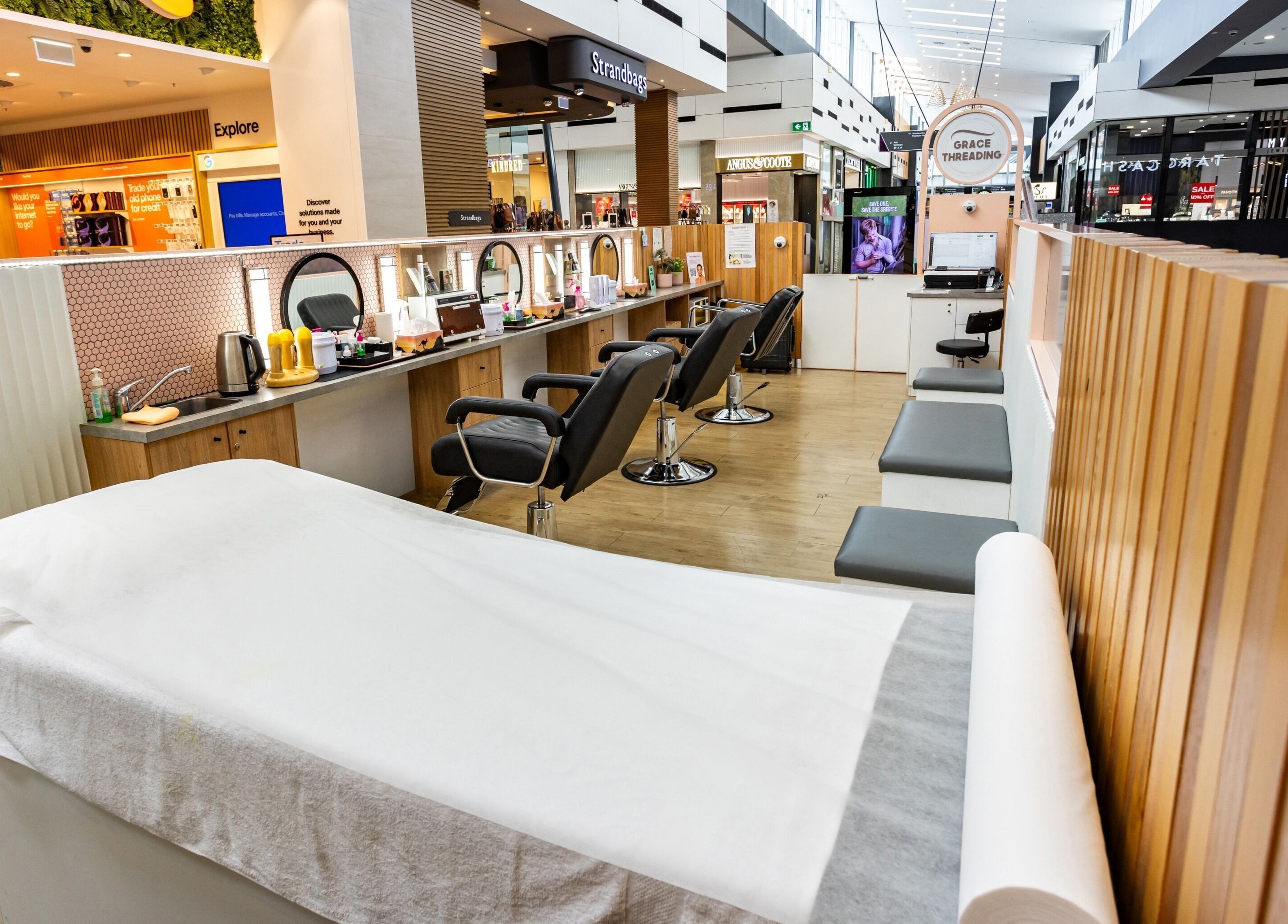 Grace Threading - Orion Springfield Central salon interior in Springfield Central, Queensland, AU with modern chairs and decor.