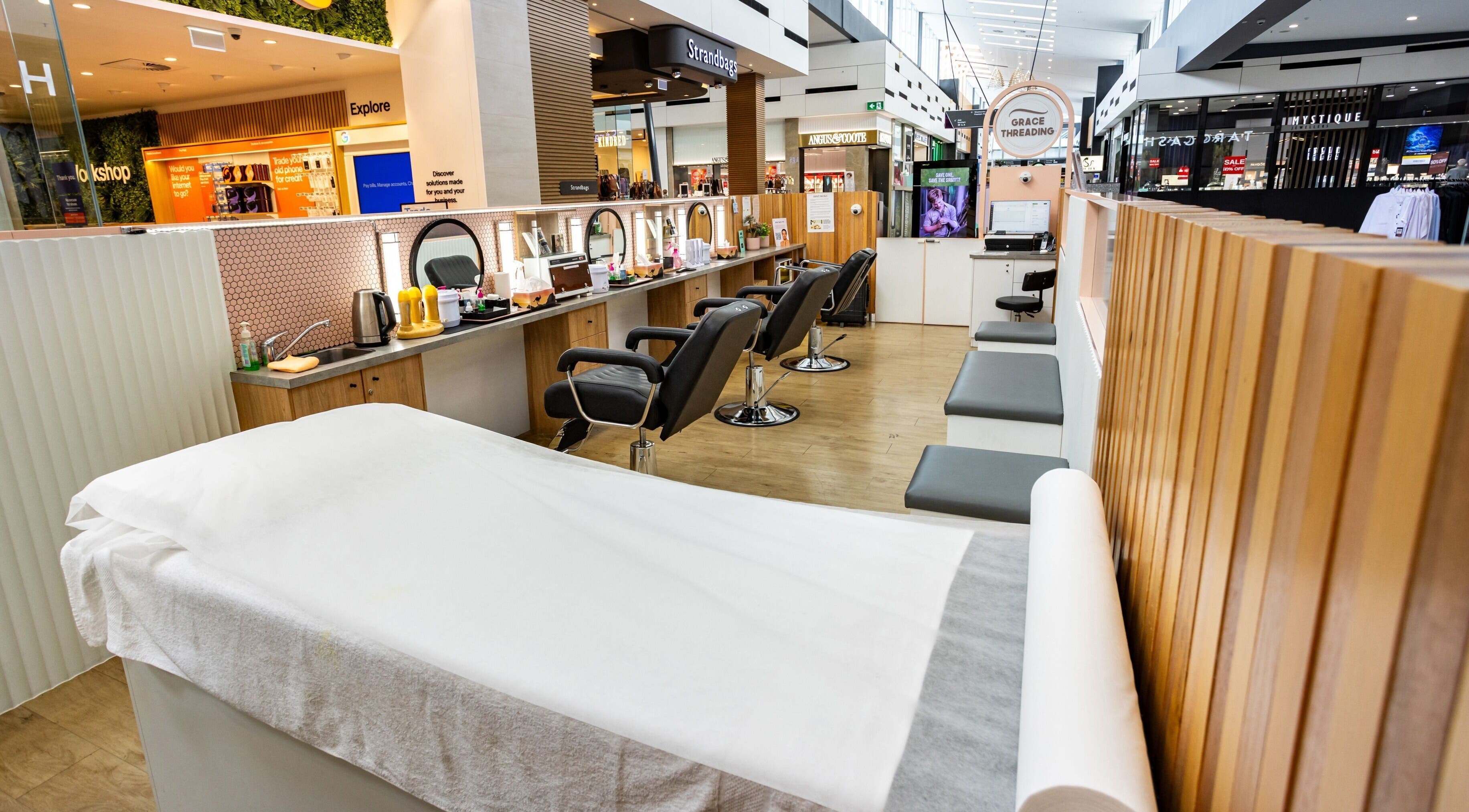 Grace Threading - Orion Springfield Central salon interior in Springfield Central, Queensland, AU with modern chairs and decor.