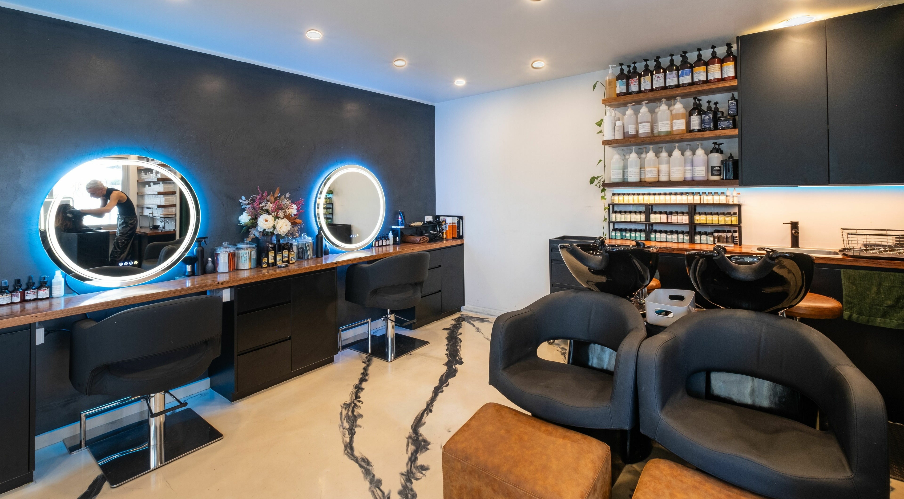 Interior of Dealis Hair Boutique in Manly, New South Wales, AU with chic styling stations and elegant decor.
