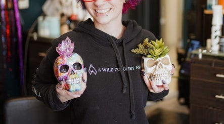 Person holding colorful decorative skulls at A Wild Colorist Appears salon in Palatine, Illinois, US.