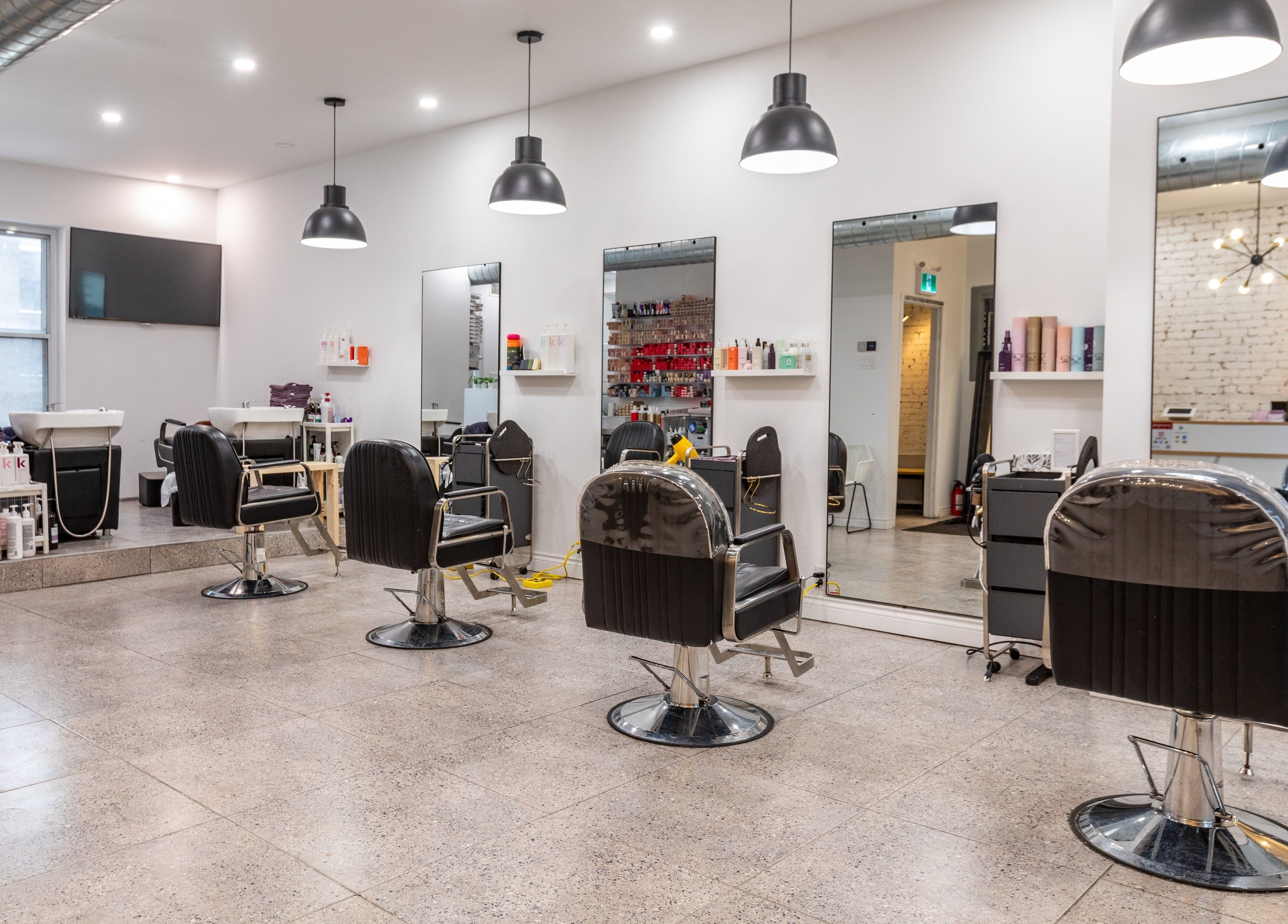 Modern interior of IN Salon-Saint-Mathieu with stylish salon chairs and mirrors in Montréal, Québec, CA.