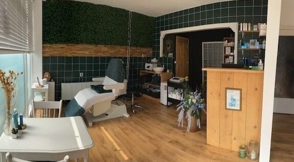 Rustige behandelkamer bij MOOI By Martine in Bodegraven, Zuid-Holland, NL, met groen interieur en houten details.