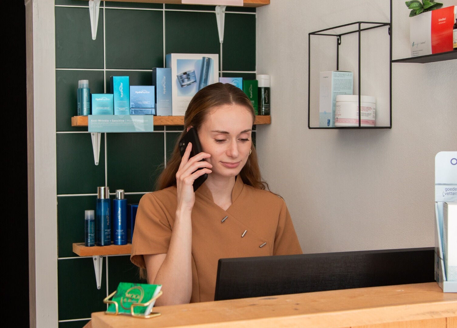 Receptioniste bij MOOI By Martine in Bodegraven, Zuid-Holland, NL, in gesprek met klant.