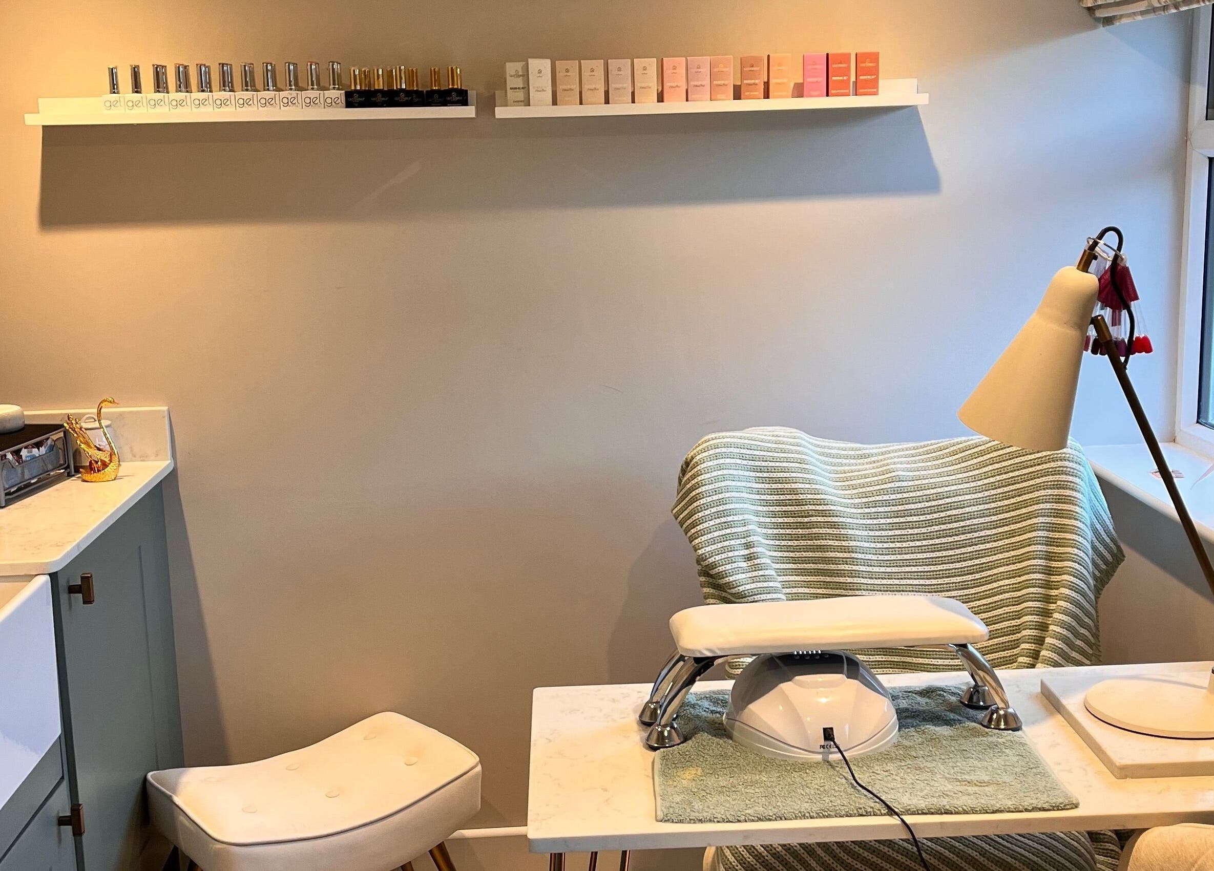 Nail station at Sophie's home salon in Bognor Regis, England, GB, featuring polishes and comfortable seating.