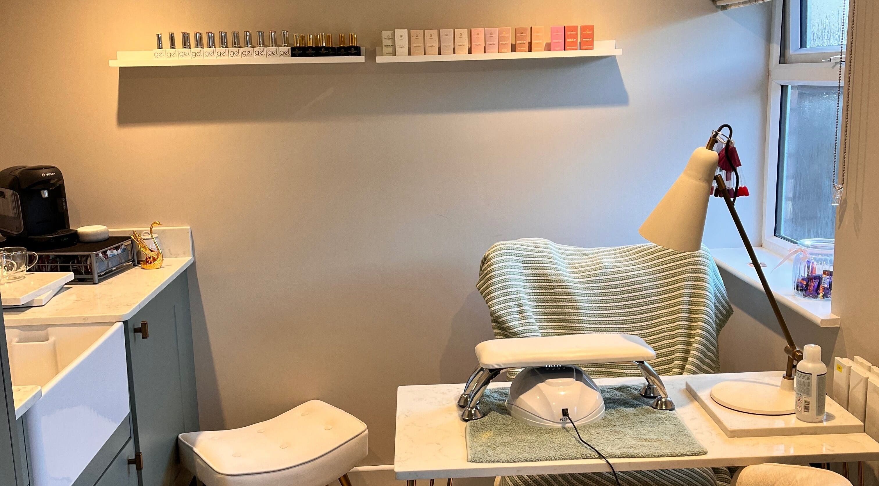 Nail station at Sophie's home salon in Bognor Regis, England, GB, featuring polishes and comfortable seating.