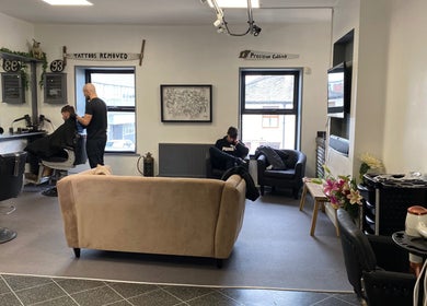 Interior of Fitzys Hair and Beauty, Accrington, showing a barber working and a cozy waiting area.
