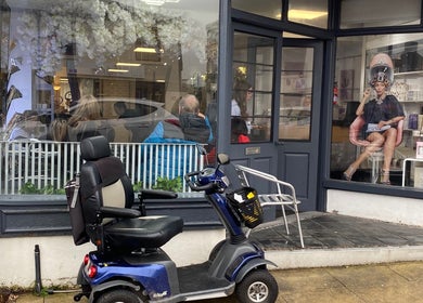 Exterior of Fitzys Hair and Beauty in Accrington, England, with a mobility scooter parked outside.