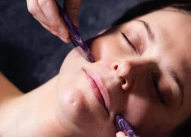 Woman enjoying facial massage at Mud Beauty, Hook, England, GB, enhancing relaxation and skin rejuvenation.