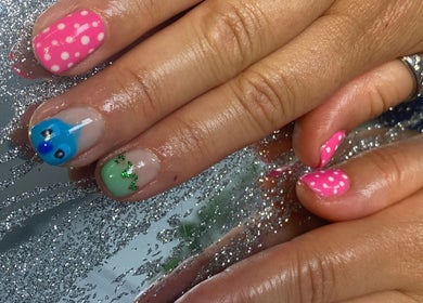 Colorful, detailed nail art design at Mud Beauty, Hook, England, GB on sparkly background.
