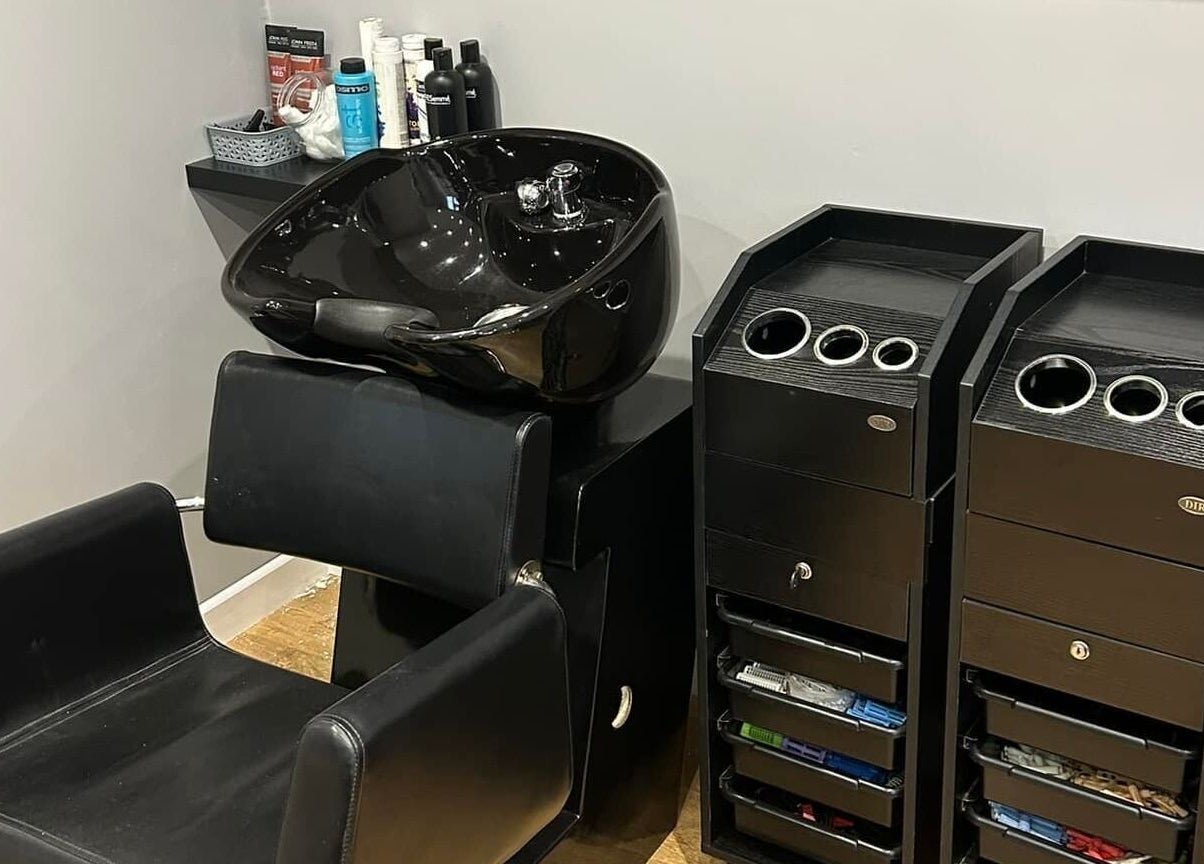 Modern hair washing station at Heads Up 34 Salon, Wickham, England, GB, featuring sleek black design.