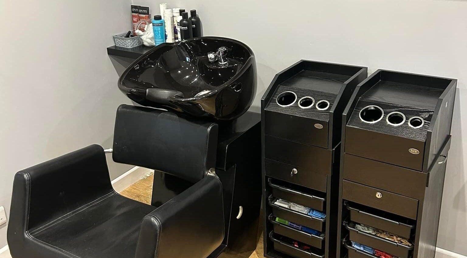 Modern hair washing station at Heads Up 34 Salon, Wickham, England, GB, featuring sleek black design.