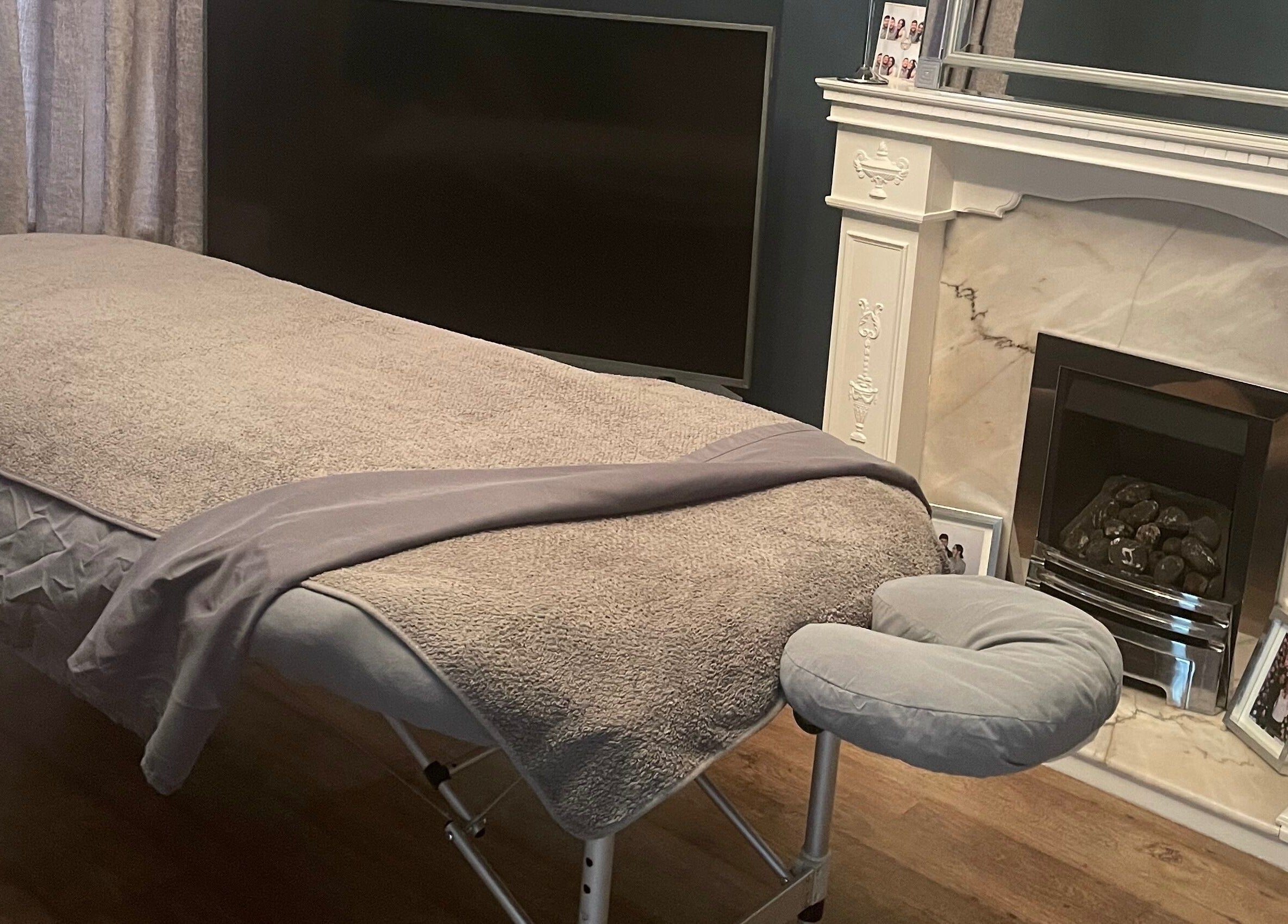 Massage table setup in Graceful Aura - Mobile Services Liverpool, England, GB near a cozy fireplace.