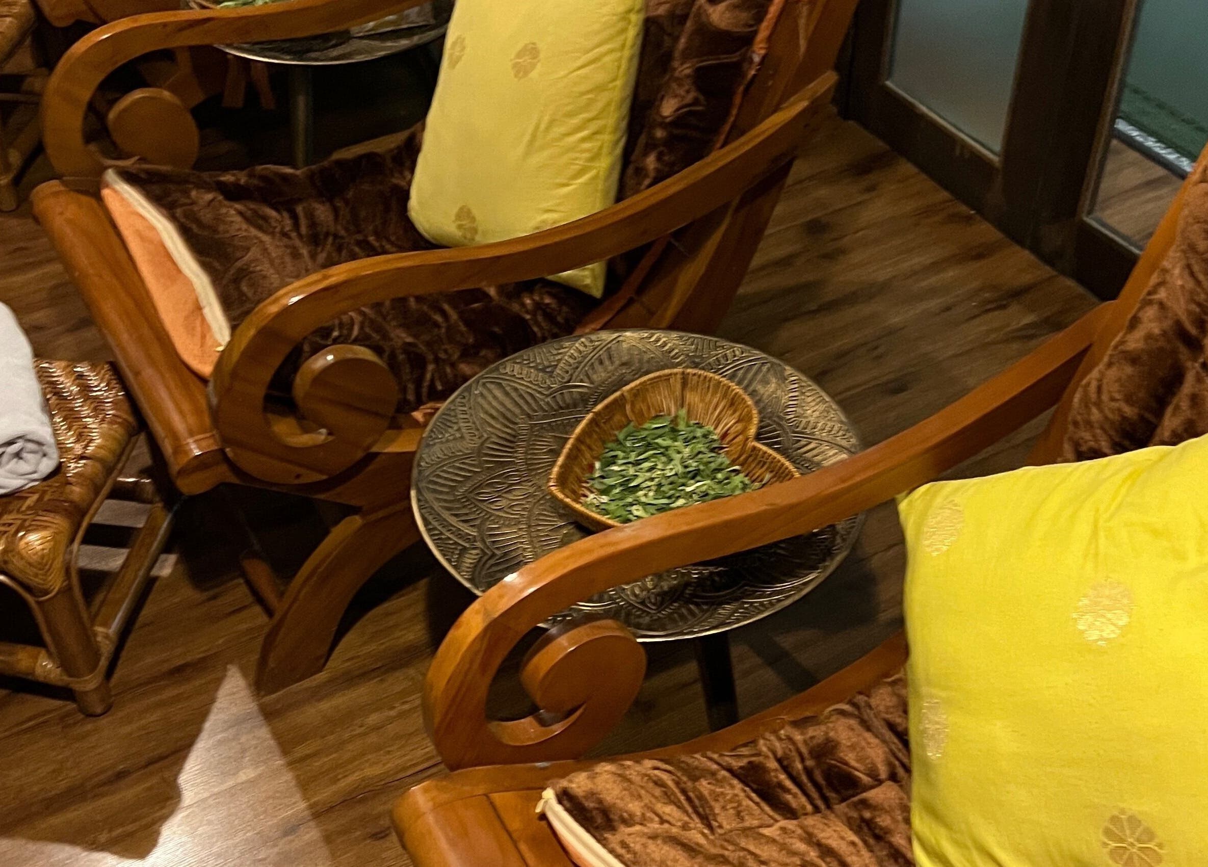Luxurious seating at Nur Taj Spa and Beauty in Kuala Lumpur, MY with cushions and a herb-filled dish.