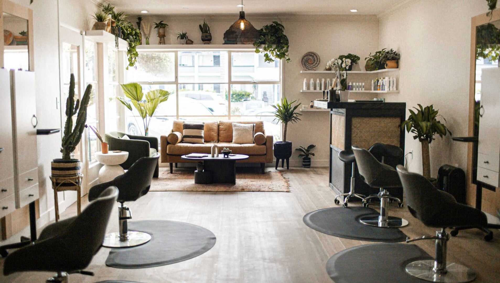 Modern, chic interior of The Acacia Salon in San Diego, California, US, featuring stylish seating and greenery.